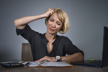 depressed business woman working overwhelmed at office with laptop computer feeling exhausted suffering headache holding her head in depression and job stress
