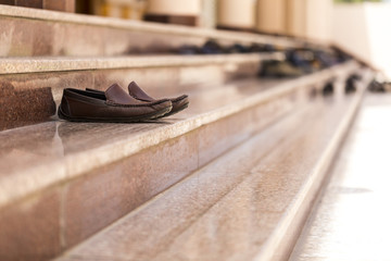 Obraz na płótnie Canvas Shoes on the steps of a mosque
