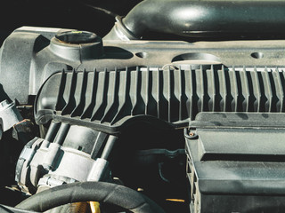 View of powerful car gasoline Internal combustion engine with many details over the hood, a system of interconnected parts that makes it possible to move, sunny day and sand on the background