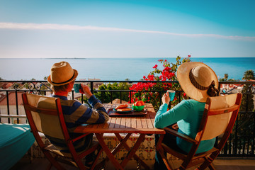 young couple have breakfast on balcony terrace with sea view