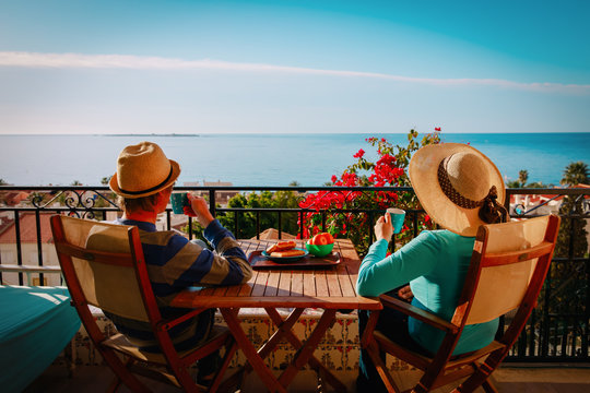 Young Couple Have Breakfast On Balcony Terrace With Sea View