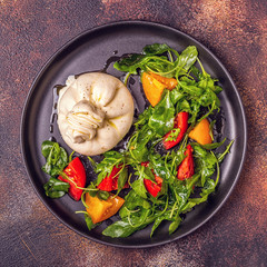 Italian cheese Burrata with fresh arugula, tomatoes, olive oil