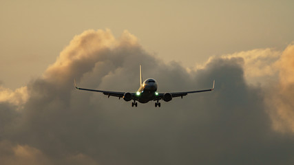 High contrast of jet plane landing against clouds