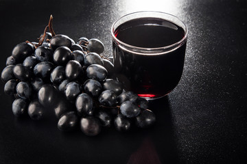 Obraz na płótnie Canvas Black grapes and a glass of wine.