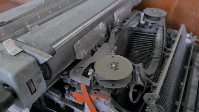 A broken typewriter is shown as well as the various parts contained therein.
