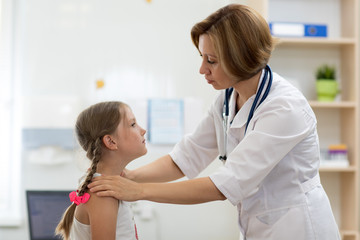 Fototapeta premium Doctor pediatrician testing little child girl tonsils