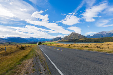 Car on the road trip,  Rural Scene of Asphalt Road with Meadow and Mountain Range, South Island, New Zealand