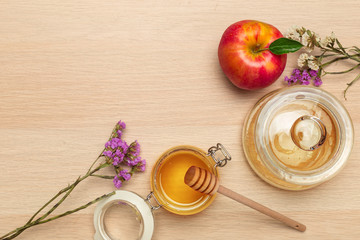 Red apple, pomegranate and honey jar for Jewish New Year on wooden board