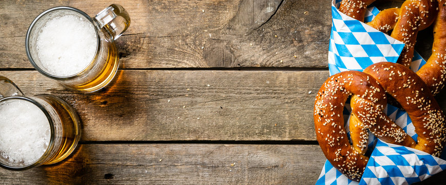 Oktoberfest concept - pretzels and beer on rustic wood background, top view