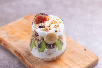 Granola with yogurt, bananas and figs. Copy space