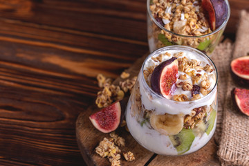 Granola with yogurt, bananas and figs. Copy space