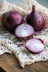Red onion and red onion slices on wooden cutting board. Red onion.