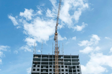 Fototapeta na wymiar Multi-storey under construction appartment building with a building crane on a sky background.