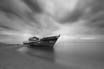 Abandoned of fishing boats seaside beach during sunrise, monochrome photography