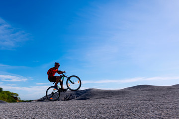 Fototapeta na wymiar Cyclist riding mountain bike on the rocky trail at sunset.