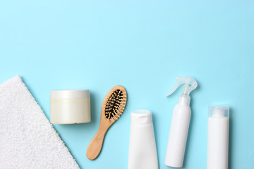 cosmetic for hair care, comb and towel on a colored background top view. flatlay 