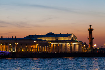 Strelka of Vasilievsky island, Neva river, Rostral column and stock exchange building in Saint-Petersburg in summer after sunset