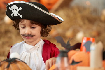 Adorable small little boy in pirate costume with hat and fake mustaches
