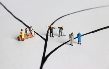 Diverse miniature people. A concept of role conflict.