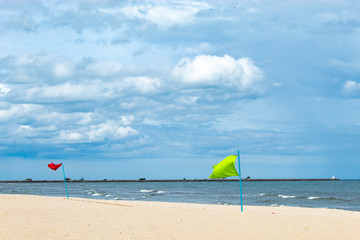 Obraz na płótnie Canvas Red flag and green flag embroidered on the beach by the sea.