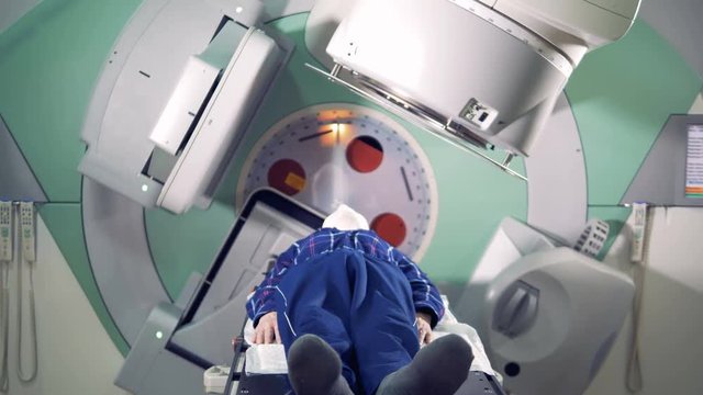 A man is getting radiated by a linear accelerator. Medical technology concept.