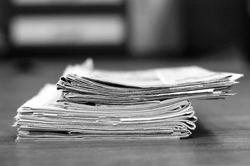 Old newspapers stacked in pile, side view        