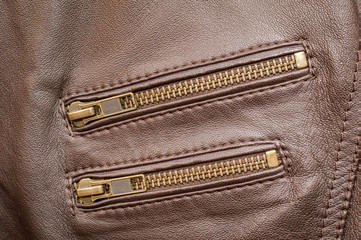 A brown leather jacket with two pocket zips closed