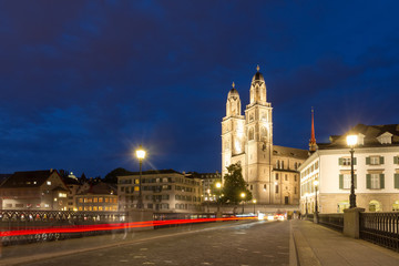 Fototapeta na wymiar Beautiful cityscape of Zurich, Switzerland, with the Grossmünster Protestant church, seen from the bridge over the river Limmat at night in summer
