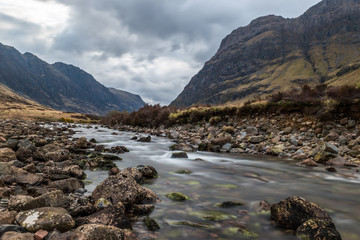 Glencoe river with smooth water flow and cloudy day. hill views at the back