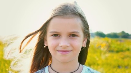 Portrait of attractive little girl with a big brown eyes on nature background with developing hair