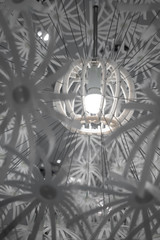 Closed up round bulb at the center of white modern abstract lamp shade