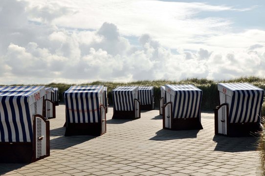 Strandk&ouml;rbe an der Strandpromenade mit Blick in den Wolkenhimmel