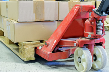 Hand pallet truck with cardboard boxes close up.