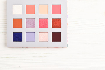 Eye shadow palette on white wooden background. Copy space.