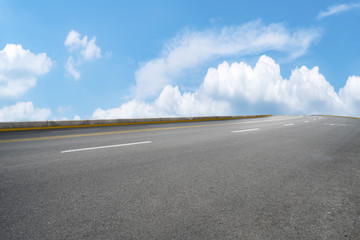 Road pavement under blue sky and white clouds