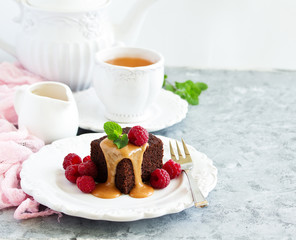 Sticky pudding with caramel sauce and fresh raspberries.
