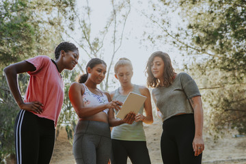 Group of active women looking at a digital tablet