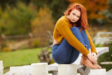 Outdoors autumn portrait of beautiful woman with red hair