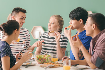 Friends eating at table in kitchen