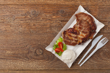 Fototapeta na wymiar Grilled pork neck served on paper trays.