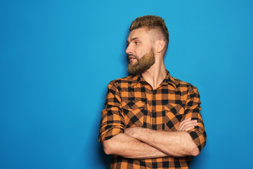 Portrait of handsome man with dyed hair and beard on color background