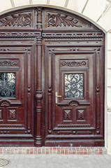 Vintage brown wooden door with arch at the top in an old house