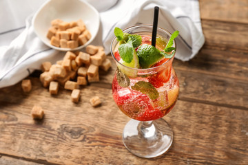 Glass of fresh strawberry mojito on wooden table