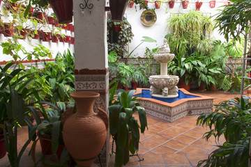 Detalle de típico patio andaluz con fuente de agua en el centro y decorado con diferentes tipos de...