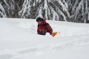 Fototapeta na wymiar Adventurer digs a cave in the snow during a snowfall