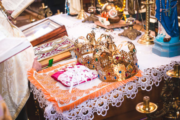 Two crowns before the wedding ceremony in church. Golden rings.