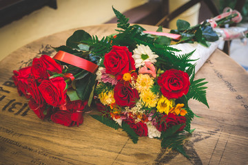 Flower bouquets with yellow and red roses. Sun flowers and rose buds. Bouquet on the table.