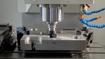 automatic cutting machine is carving holes in a metal detail in a plant, working CNC apparatus, close-up