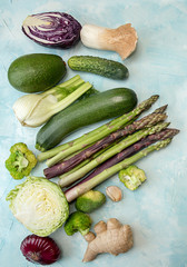Set collection spring summer seasonal vegetables asparagus zucchini cabbage etc over on blue background. Flat lay. Overhead.