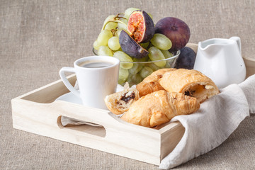 breakfast in bed with fruits and pastries on a tray